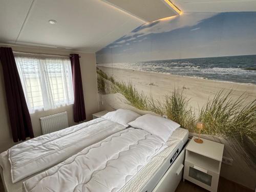 a bedroom with a bed with a view of the beach at ZeeGlück in Oostkapelle