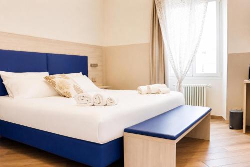 a blue and white bed with two towels on it at Sanremo Apartments - A Due Passi in Sanremo