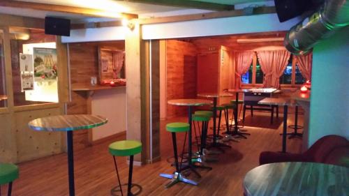 a bar with tables and stools in a room at Hotel Mira in Sedrun
