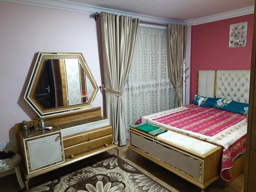 a bedroom with a bed with a mirror and a dresser at عمارة 14 in Madīnat ash Shurūq