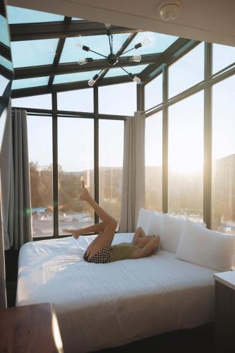 a woman laying on a bed in front of a window at Wild Sage in Orderville