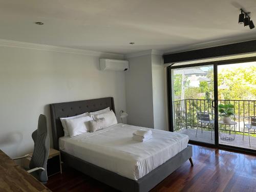 a bedroom with a bed and a balcony at Shine House in Balwyn North