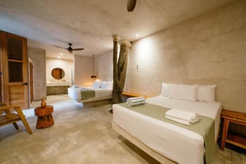 a bedroom with a large bed and a bathroom at Hotel Boutique Alma Peregrina in Valladolid
