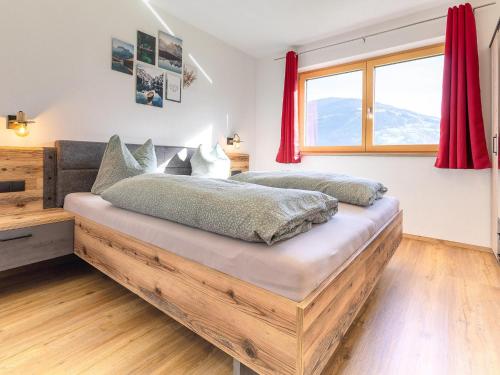 a bedroom with a large wooden bed with red curtains at Appart Zell in Zellberg