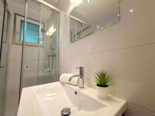 a white bathroom with a sink and a shower at Jagerhütte in Mallnitz