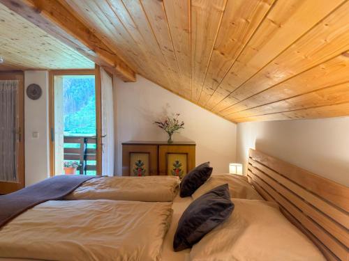 two beds in a bedroom with a wooden ceiling at Jagerhütte in Mallnitz