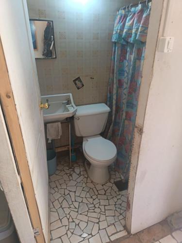 a bathroom with a toilet and a sink at Hostal Rústico Las Pircas in Alcoguaz
