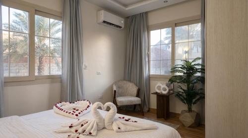 a bedroom with a bed with two heart shaped towels at Villa Golden Sunset Pyramids in Cairo