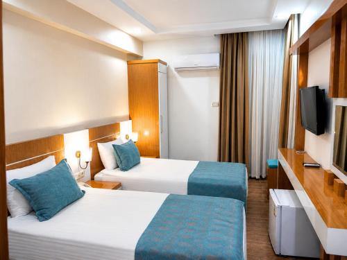 a hotel room with two beds and a flat screen tv at Esperanza Hotel in Antalya