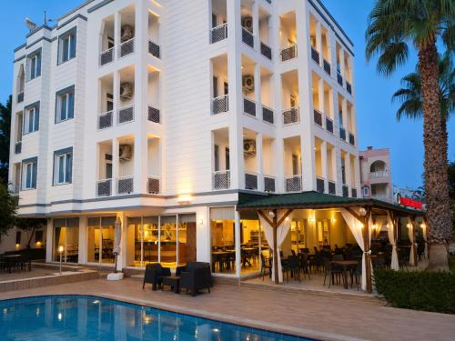 a hotel with a swimming pool in front of a building at Esperanza Hotel in Antalya