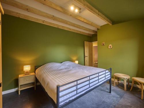 a bedroom with a bed in a green wall at Sientjeshof 1 in Diessen