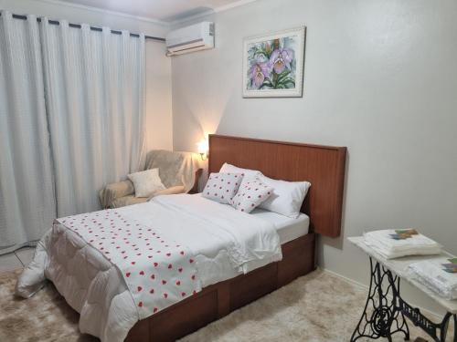 a small bedroom with a bed and a chair at Quarto suite 1 dorm Prox da Casa de Saude mais salas e estacionamento in Santa Maria