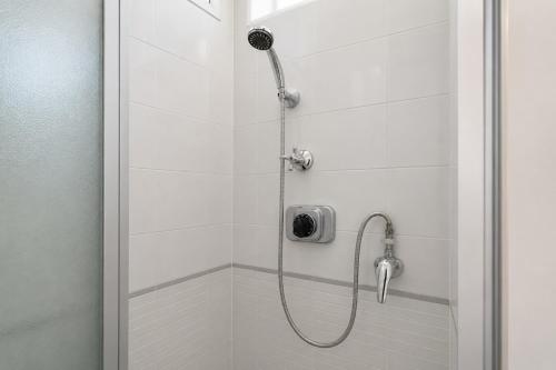 a shower with a shower head in a bathroom at Malù camera tripla in appartamento - lungomare Crotone in Crotone