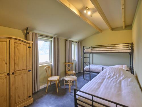 a bedroom with a bunk bed and two chairs at Sientjeshof 2 in Diessen