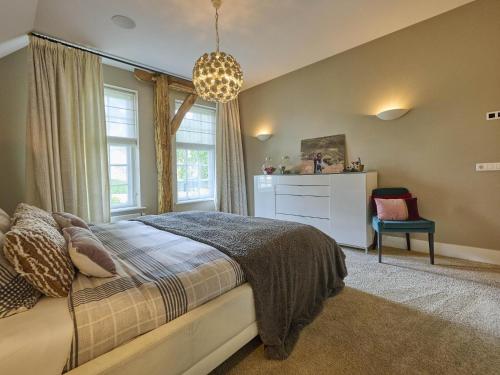 a bedroom with a bed and a window and a chair at De Binnenhof in Vriezenveen