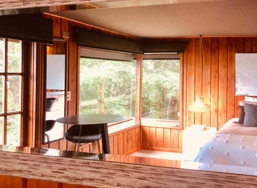 a bedroom with a table and a bed and a window at Meular Room One in Castro