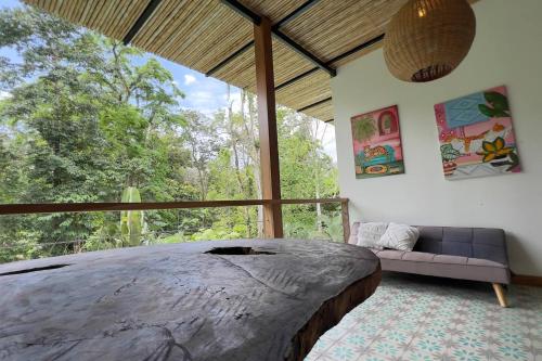 a bedroom with a large bed and a large window at Casa Siwa in Cahuita