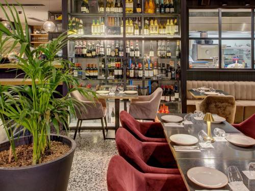 a restaurant with tables and chairs and plants at Number 11 St Julian's Malta - Handwritten Collection in St. Julianʼs