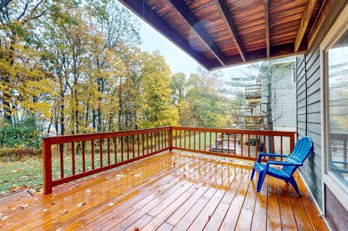 a porch with a blue chair on a wooden deck at Hibernation Hideaway in McHenry