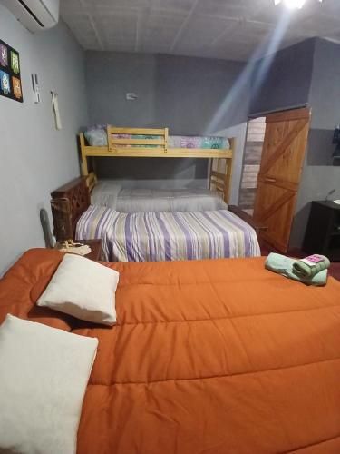 a bedroom with two beds and a bunk bed at Hospedaje Tidae in Tinogasta