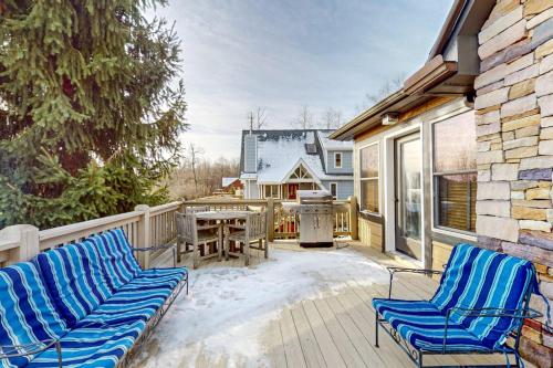 a deck with two chairs and a table and a grill at Bear's Eye View in McHenry