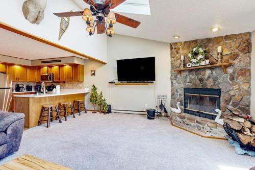 a living room with a stone fireplace and a tv at Oakland Oasis in Oakland