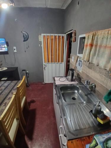 a small kitchen with a sink and a door at Hospedaje Tidae in Tinogasta