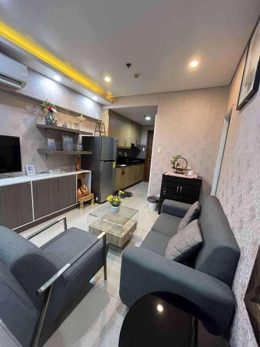 a living room with two couches and a kitchen at Shell Residence Pasay City in Manila