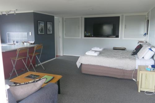 une chambre d'hôtel avec un lit, un canapé et une table dans l'établissement Atalaya, à Waihi Beach