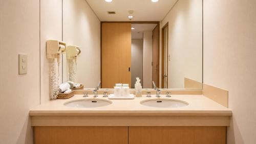 a bathroom with two sinks and a large mirror at Hotel Mielparque Kumamoto in Kumamoto