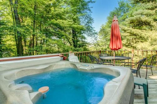 a hot tub on a deck with a table and an umbrella at Life's A Bear in McHenry