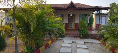 a house with palm trees in front of it at Surya farms in Rajiv Gandhi International Airport