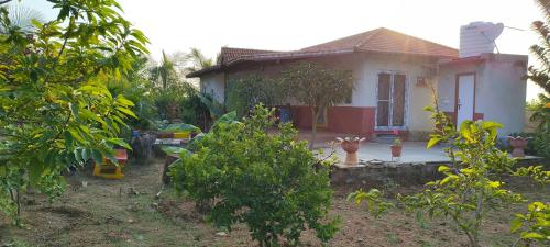 a small house with a garden in front of it at Surya farms in Rajiv Gandhi International Airport
