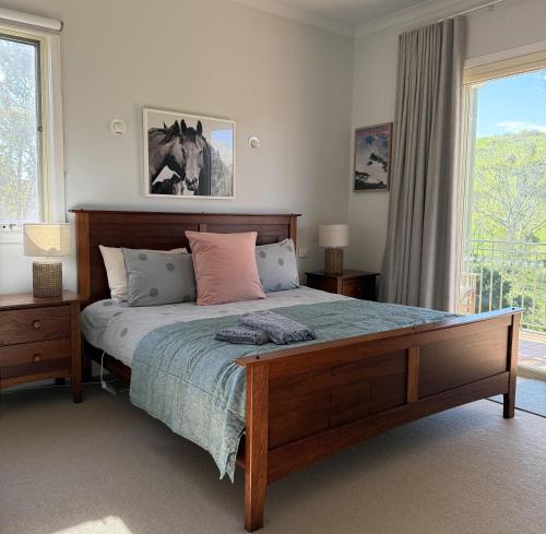 a bedroom with a large bed and a window at The River House in Merrijig