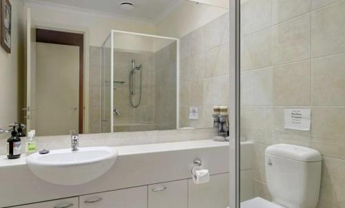a bathroom with a sink and a toilet and a shower at The River House in Merrijig