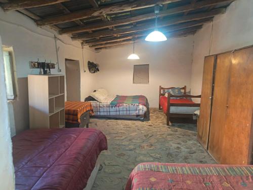 a bedroom with two beds and a couch in a room at Hostal Rústico Las Pircas in Alcoguaz