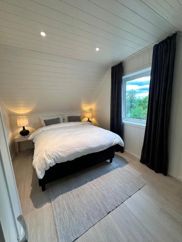a bedroom with a bed and a large window at Cozy Home in Sortland in Sortland