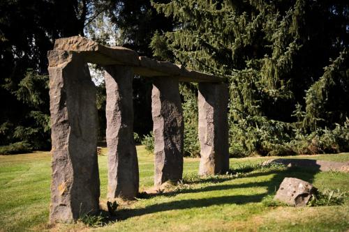 a stone arch in a field of grass at Hotel Wilhelmshöhe Auderath in Auderath