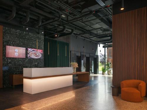 a lobby with a reception desk and a chair at Pullman Zagreb in Zagreb