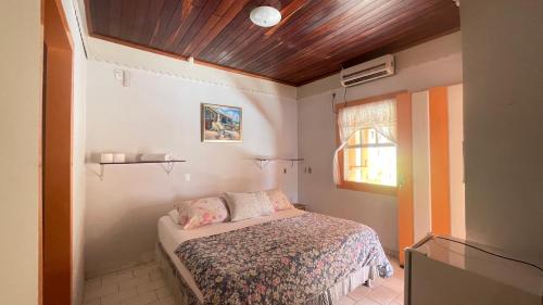 a small bedroom with a bed and a window at Hospedagens da Lucia in Pirenópolis