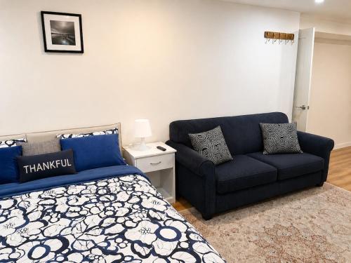a bedroom with a blue bed and a couch at Azure Glow Studio in Brossard