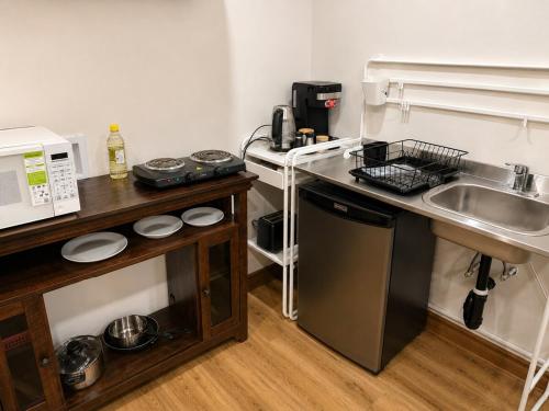 a small kitchen with a sink and a microwave at Azure Glow Studio in Brossard