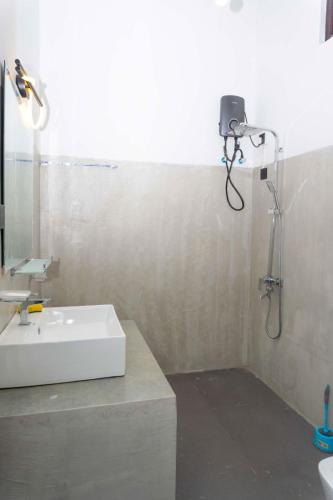 a bathroom with a sink and a shower with a camera at Hidden Heaven Grove-Kandy in Kandy