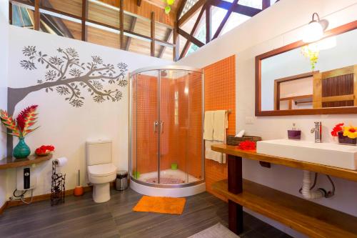 a bathroom with a shower and a toilet and a sink at La Magia Bungalows in Puerto Viejo