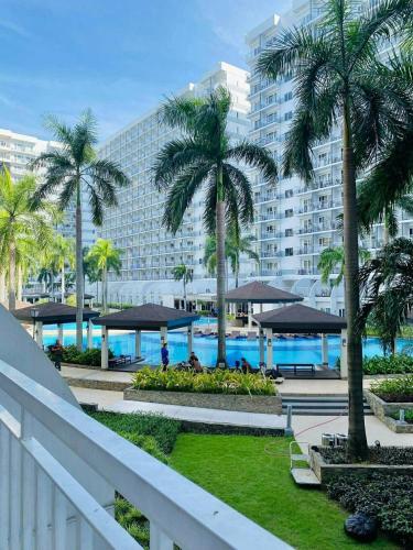 a view of a resort with palm trees and a pool at Shell Residence Pasay City in Manila