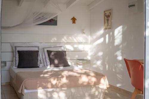 a bedroom with a bed with a dog sitting on it at Combava à Marie Galante in Grand-Bourg