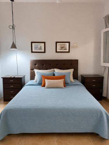 a bedroom with a blue bed with orange pillows at Dunas y Cielo in Tinogasta