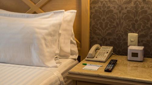 a hotel room with a bed and a phone on a table at Holiday Inn Queretaro Centro Historico by IHG in Querétaro