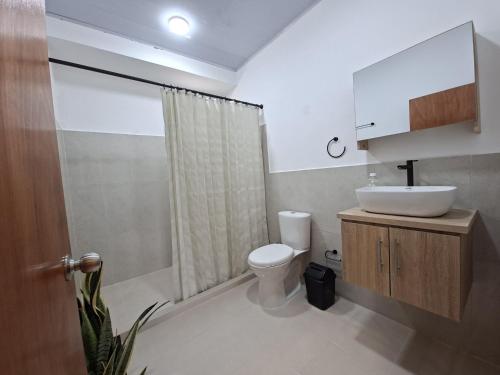 a bathroom with a white toilet and a sink at Villa Kas Abao Doradal Ant in Doradal