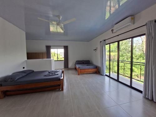 a bedroom with a bed and a large sliding glass door at Villa Kas Abao Doradal Ant in Doradal